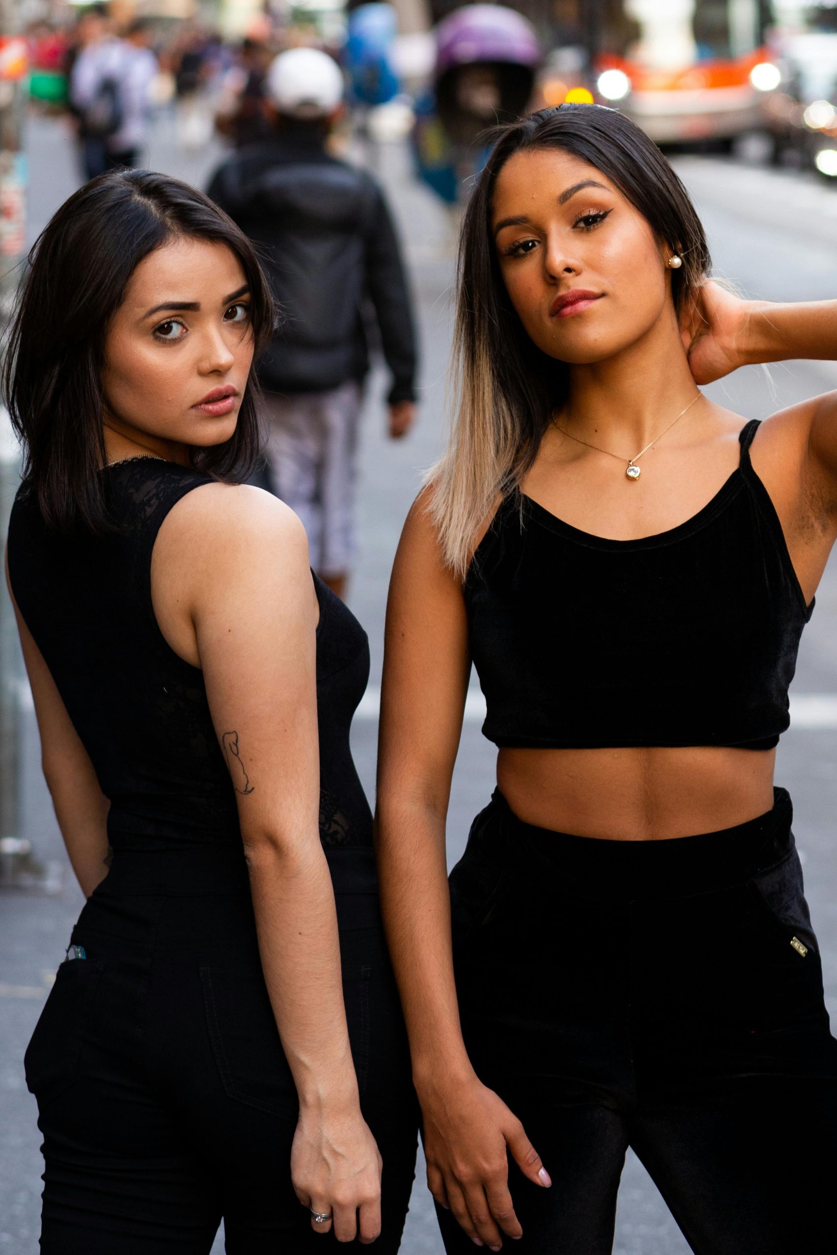 Stylish young women posing in the bustling streets of São Paulo, showcasing urban fashion.
